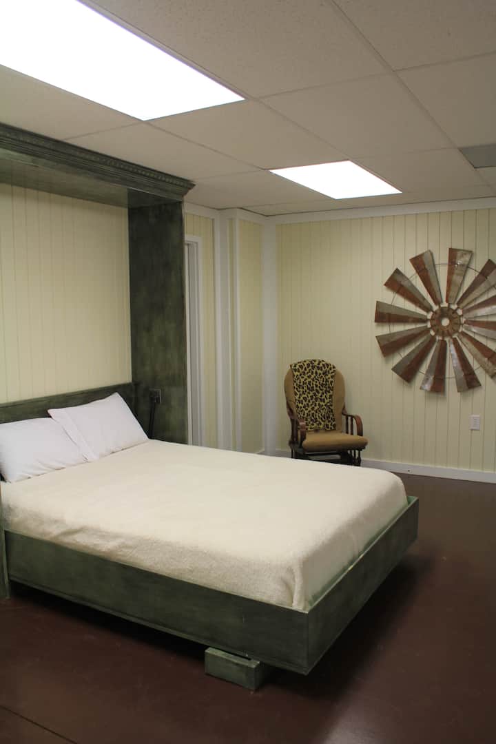 Keller - offener Bereich/Sitzbereich mit Queensize-Wandbett, Sofa und Gleitschaukel.