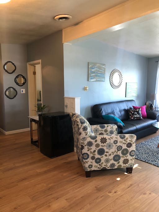Open concept kitchen and living area. Mini fridge provided with water and a microwave.