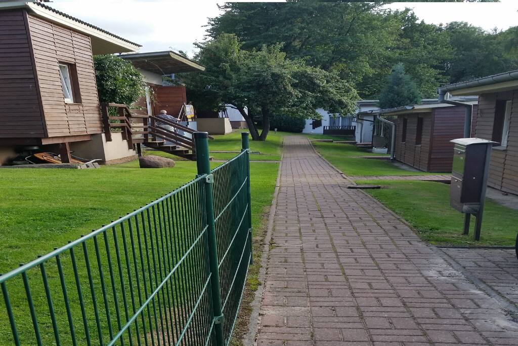 von der Strasse in die Anlage, hinten die weißen Häuser sind meine