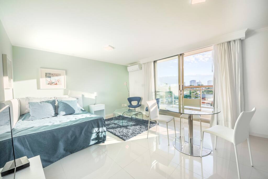 Ambiente con cama matrimonial, living y cocina integrada.