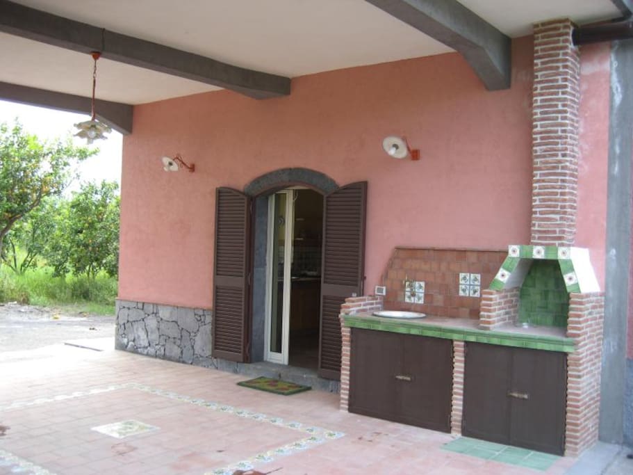 terrazzino coperto con barbecue antistante l'appartamento e giardino