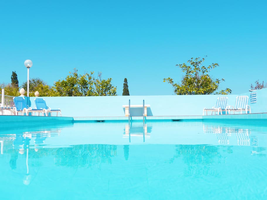Large fresh water swimming pool with a spacious sun deck area surrounded with mature gardens
