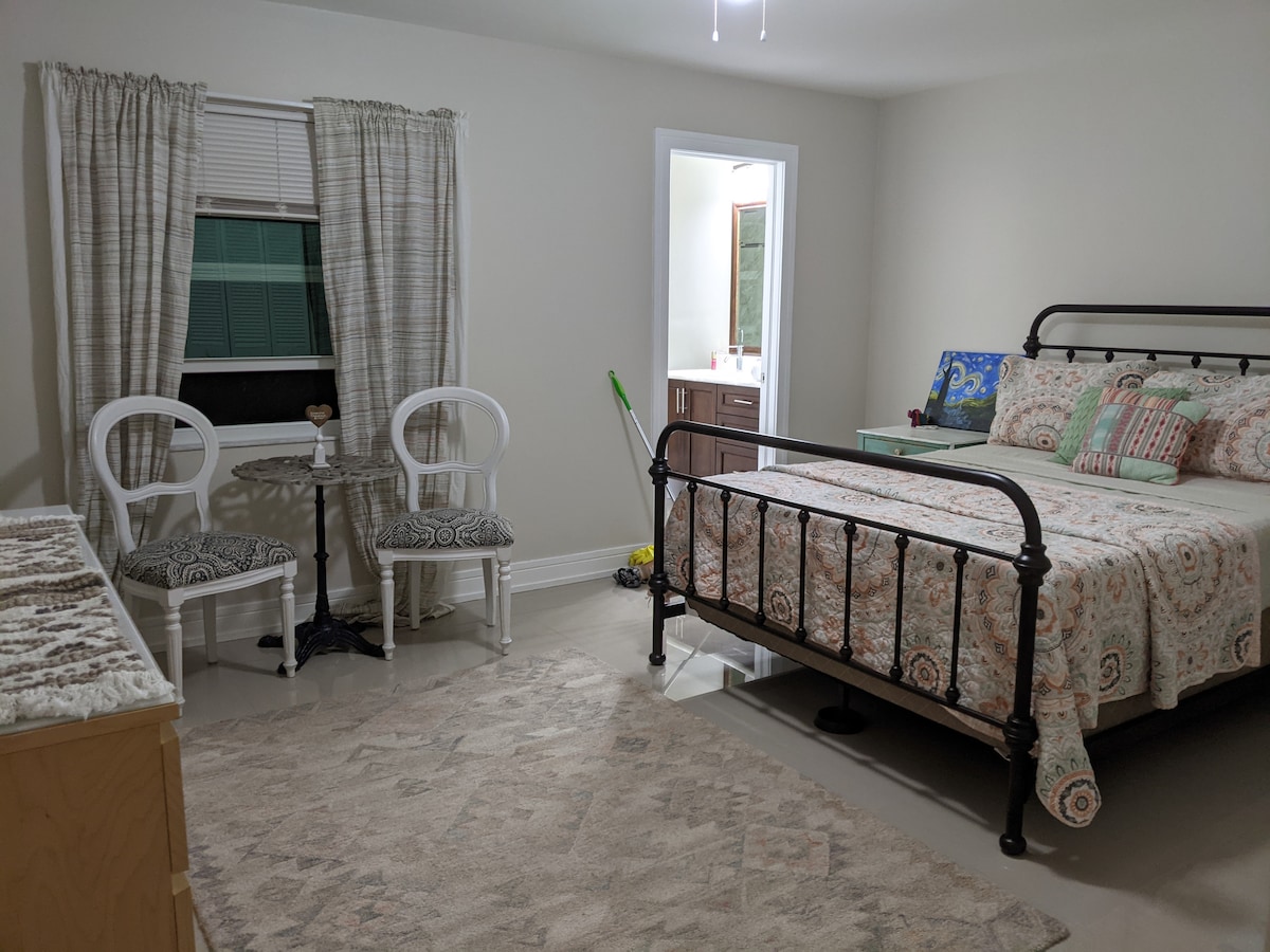 Dormitorio 3: vista de la cama tamaño queen con su mesita de noche, así como una pequeña zona de estar.