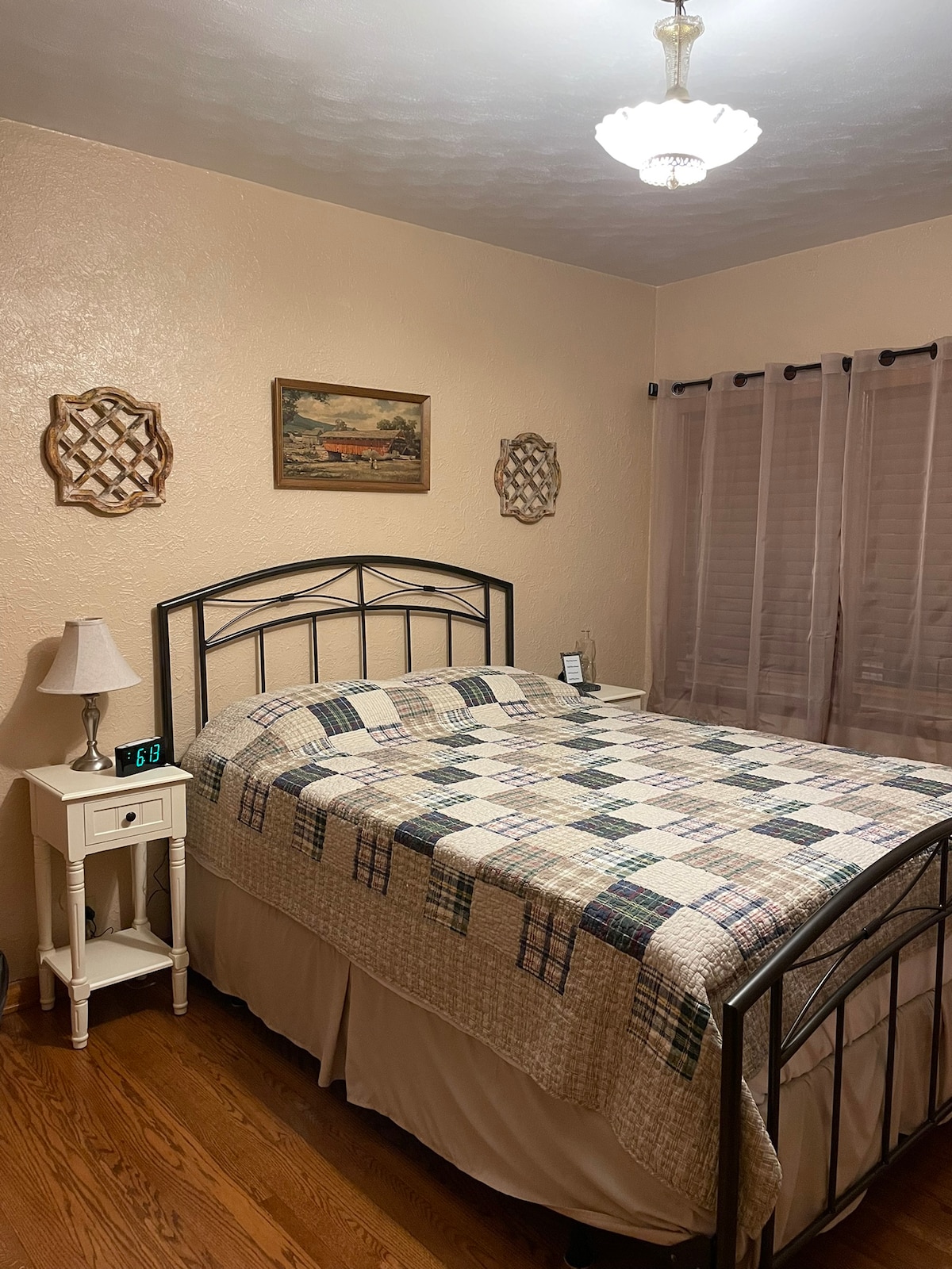First bedroom on the main floor with a queen bed. AC window unit for summer. Alarm clock has USB charging port. 
The bathroom is beside this bedroom.