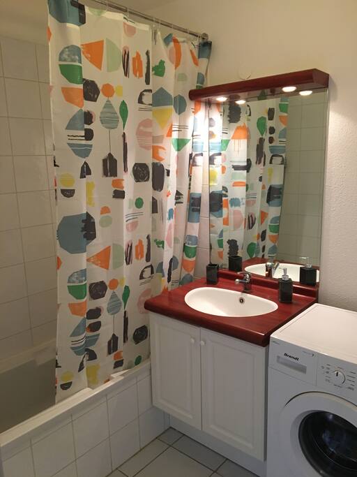 Bathroom with washing machine, shower and bathtub