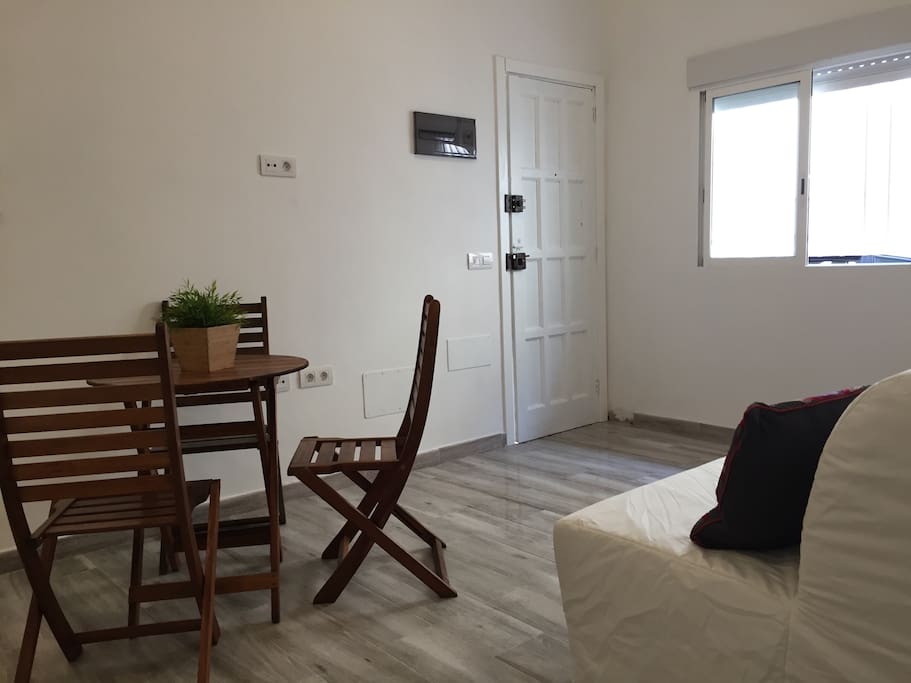 Salón comedor con sofá cama y ventilador de techo
