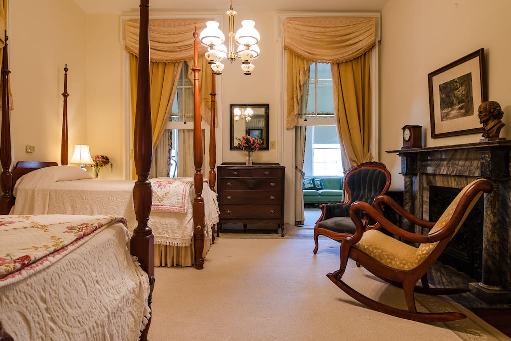 The back bedroom features two antique twin-sized beds -- original mantel, and other antique furnishings.