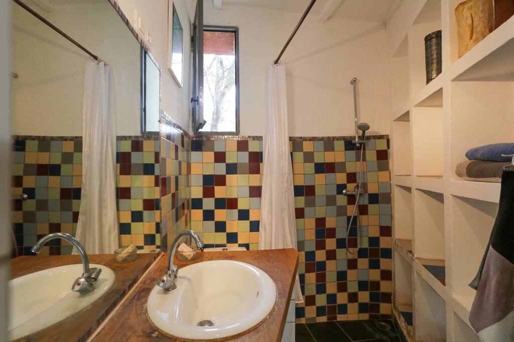 badezimmer mit lavabo und dusche. rechts ein großes nischen-regal