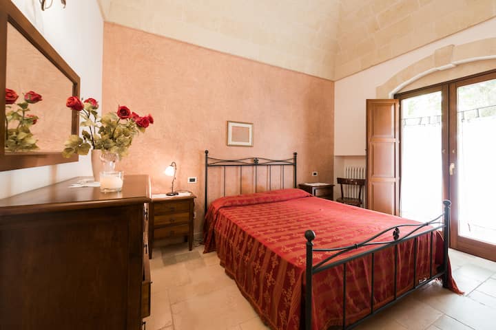 Dormitorio con cama matrimonial envuelta en bóveda de tuff