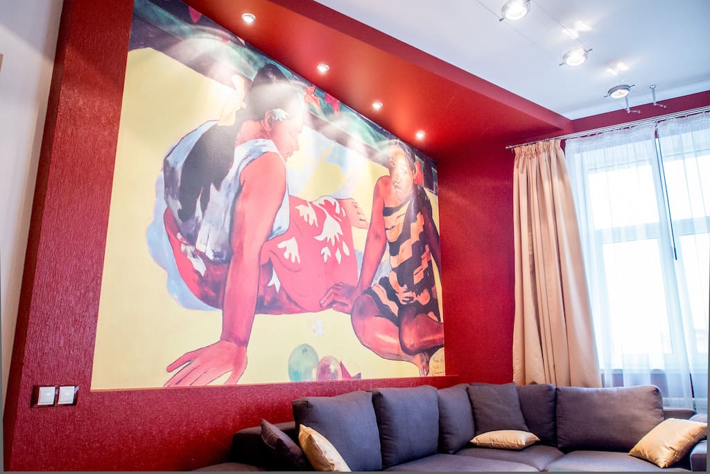 Print of famous Gauguin picture on the wall above very comfortable sofa.