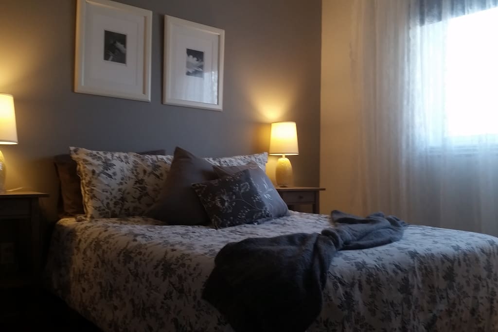 Chambre avec lit double, penderie et commode à l'étage.