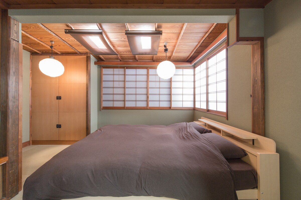 Spavaća soba s bračnim krevetom i otvorenim kliznim vratima