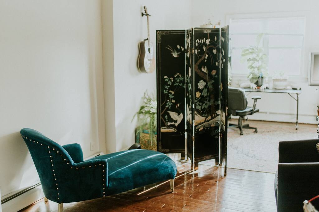 French Fainting couch and sun reflecting off of wood floors.