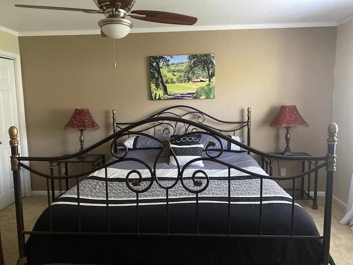 Main bedroom with King and side chair.  Private bathroom with shower, sink and toilet.  Closet with hangers.