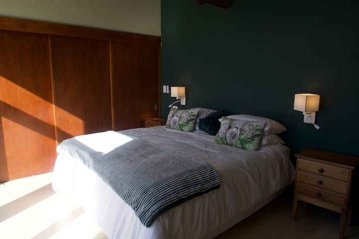 Dormitorio en la planta superior con vistas a la montaña y balcón con jardín.