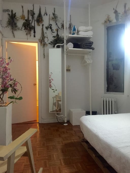 Bedroom with clothing rack, extra towels, extra pillows, and an iron.