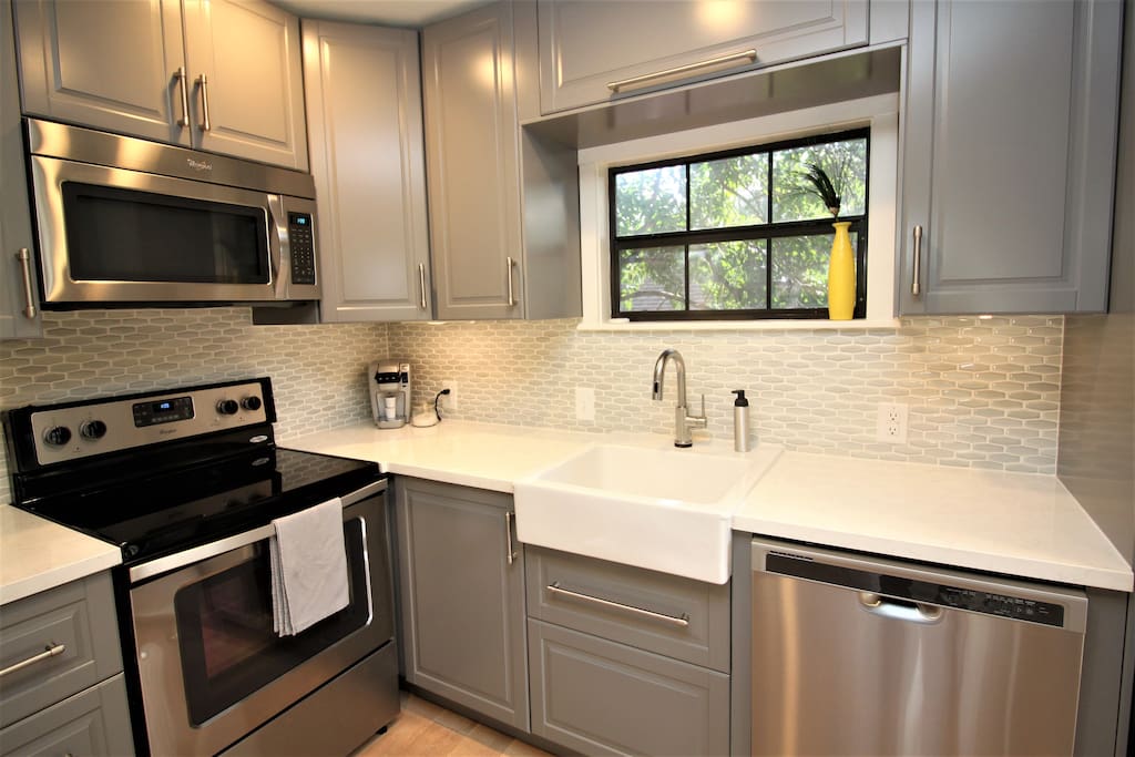 Full-sized glass-topped range, microwave, and dishwasher with apron front sink