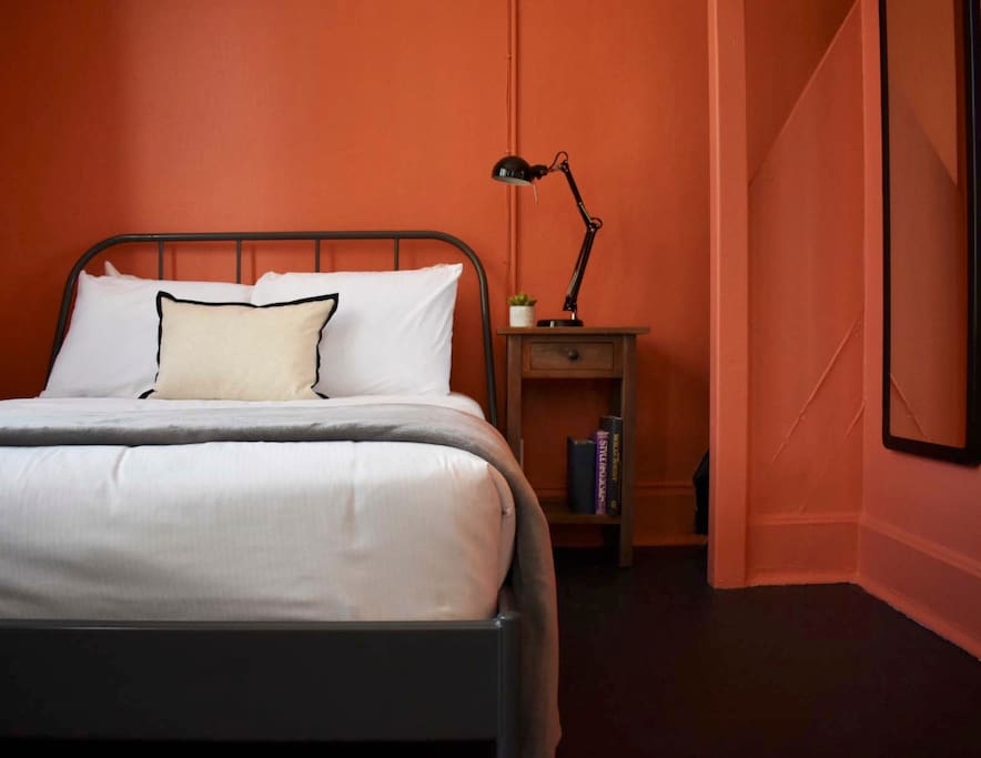 Just behind the couch is a Full-sized bed; one of two in this apartment