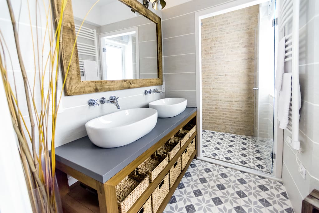 Bathroom with toilet, rain shower, two washbowls and towel heater