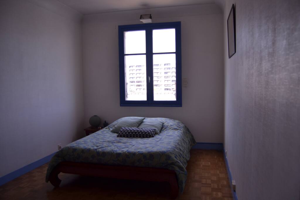 Chambre avec un lit double. La salle de bain est ouverte sur la chambre.