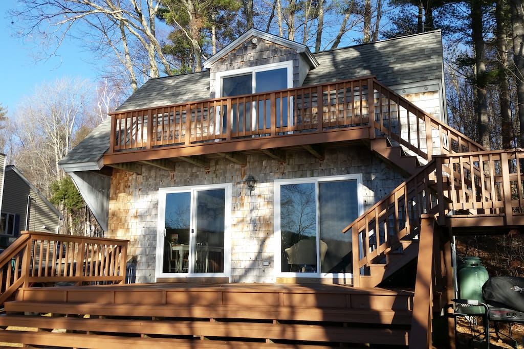 Water facing front of house with two tiered deck and great views of lake