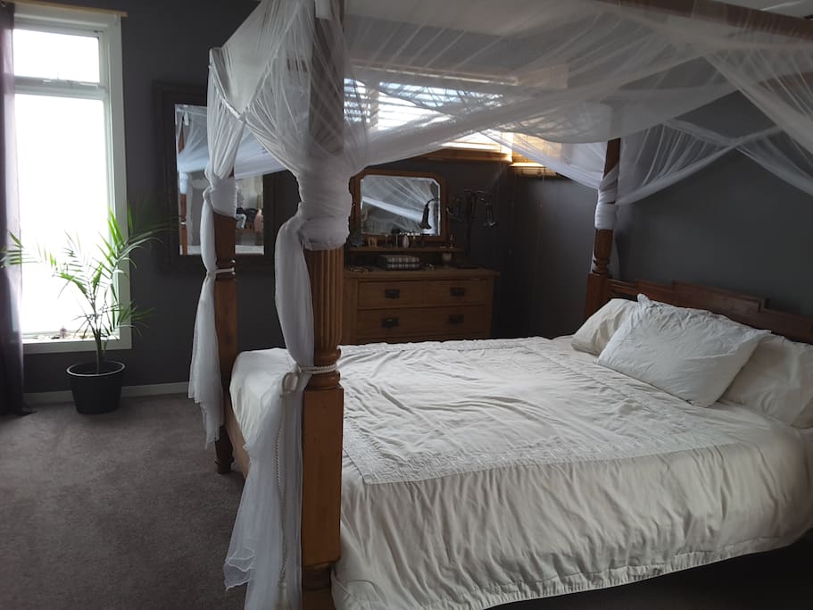 Queen size bed in large room.