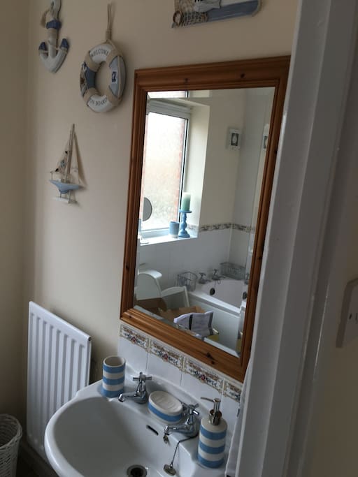 Bathroom with electric shower and full bath.