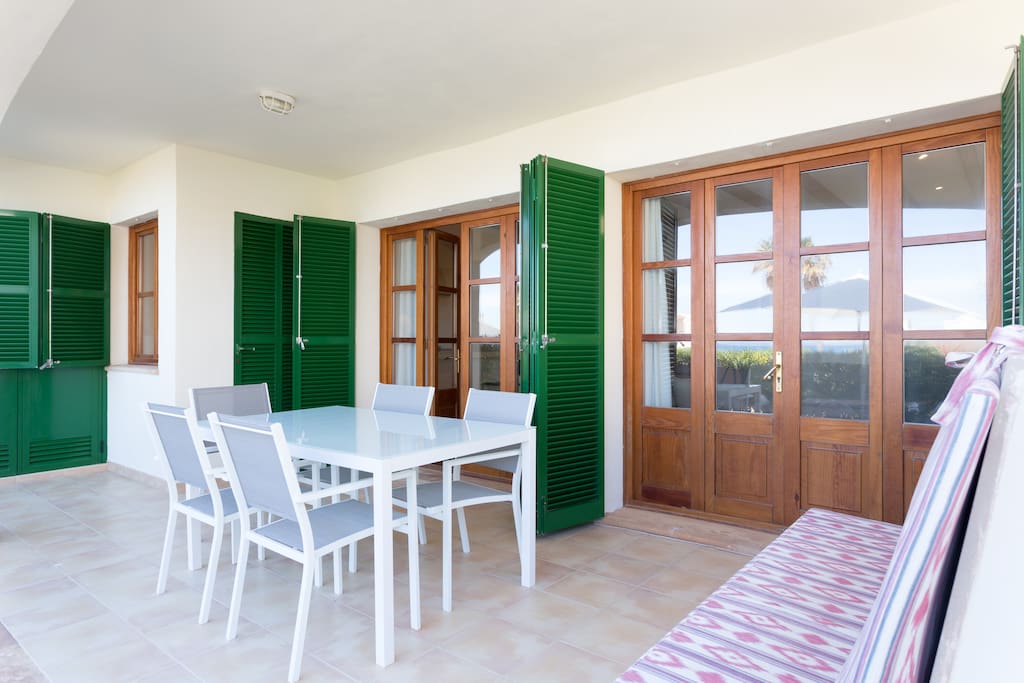 Shaded outdoor terrace space with access to kitchen and living area with dining table seating for up to 6 guests.