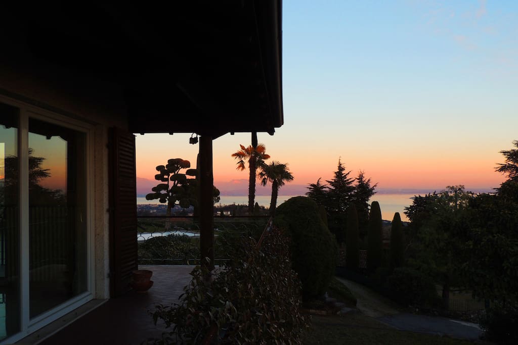 Un lato della casa su cui corre il balcone con affaccio sul lago e sul giardino (al tramonto)