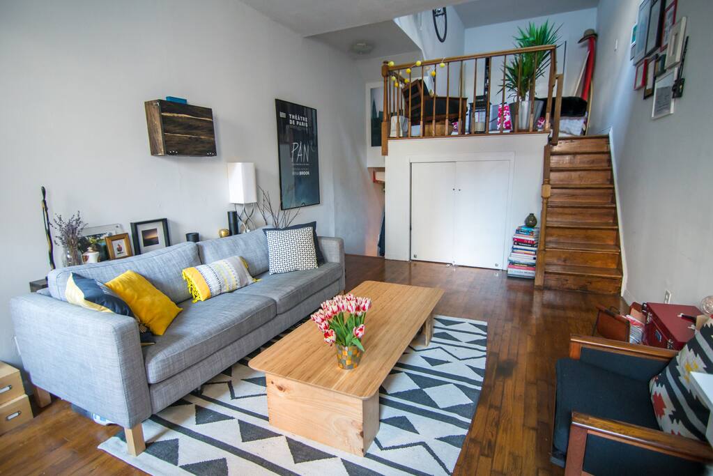 The living room on the second floor with stairs leading up to the bedroom or down to the kitchen