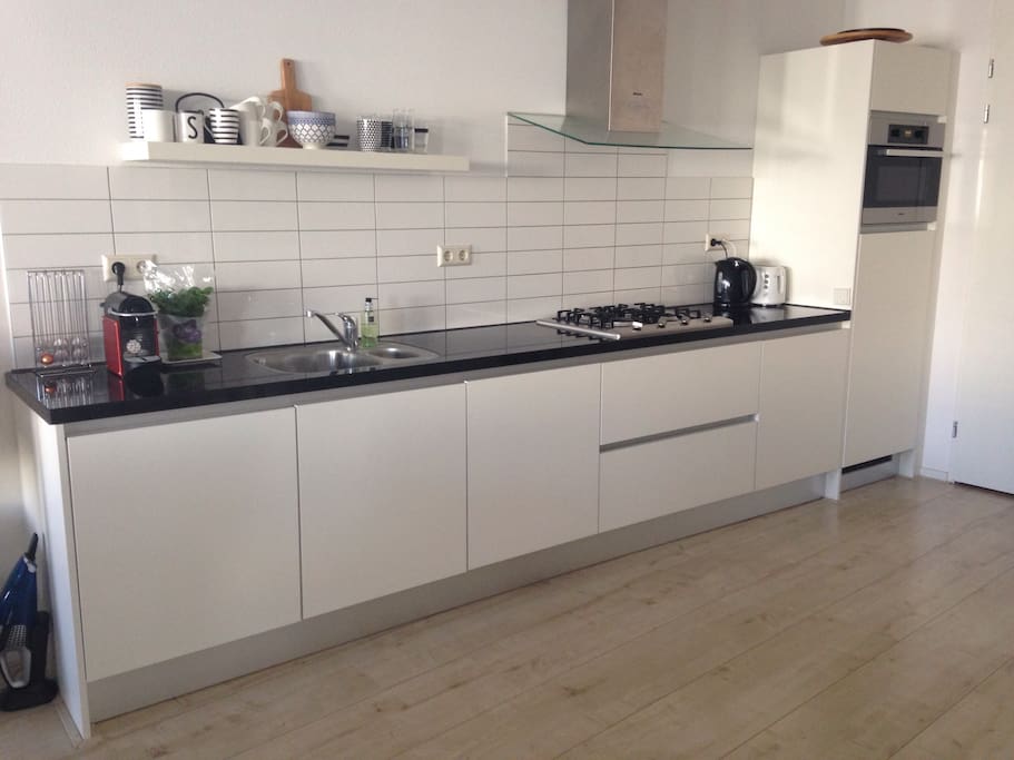 Kitchen with oven, washingmachine, coffee machine toaster, plates, towels, everything you need.