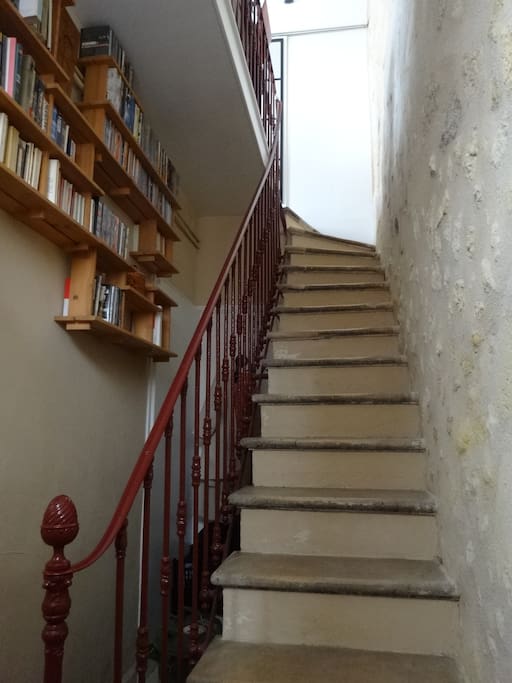 Entrée avec escalier et murs de pierre vers le 1er étage