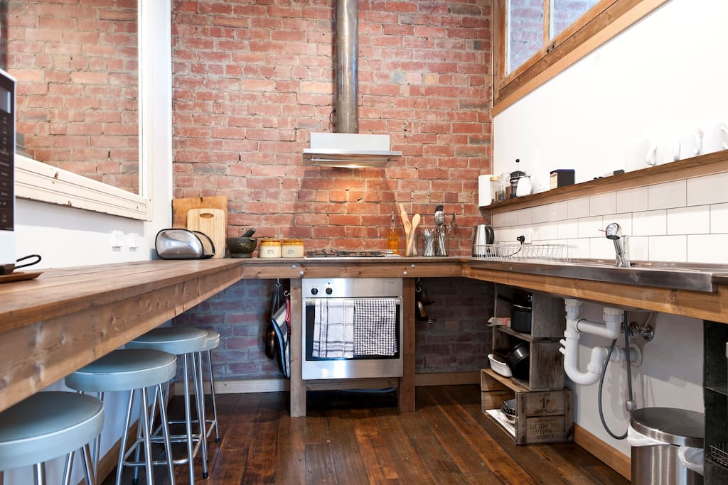 Fully equipped industrial style kitchen with gas cooktop and oven.