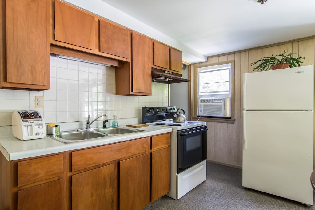 Full kitchen with stove, microwave and refrigerator