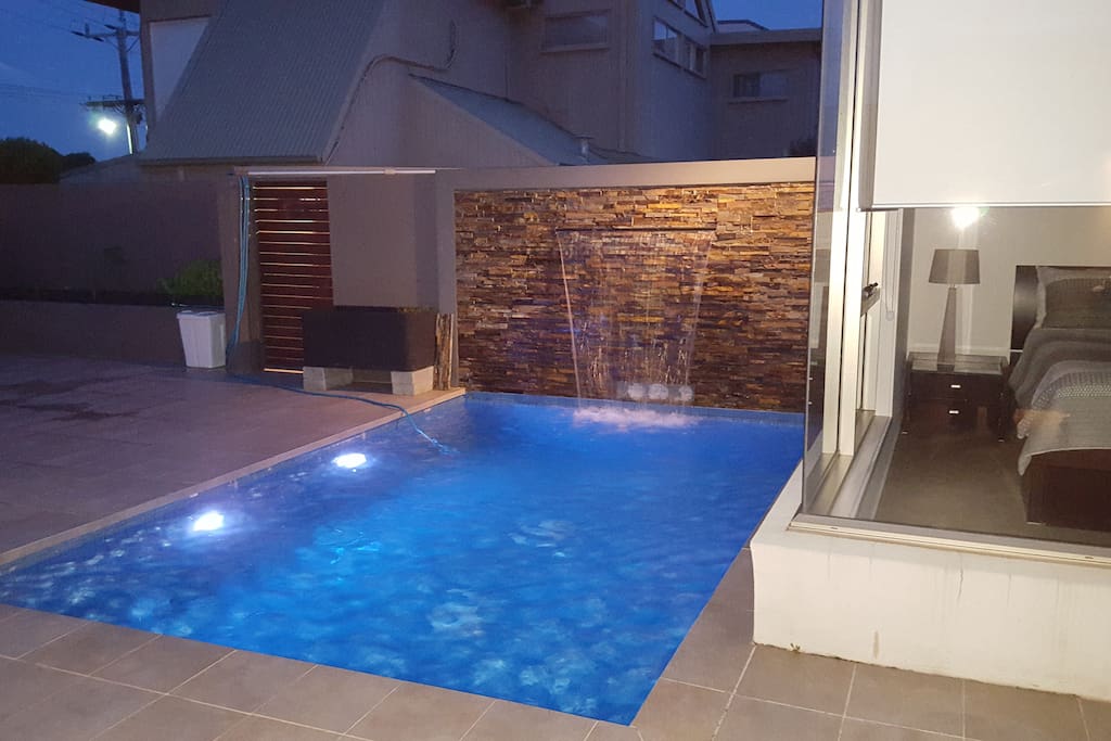 Night view of heated pool with waterfall