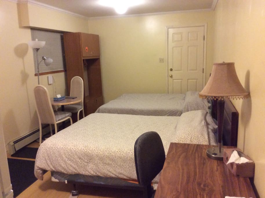 1 queen-sized and 1 double-sized bed with a table and a desk