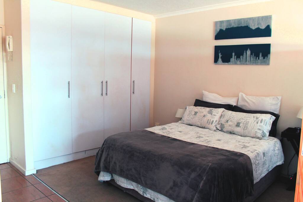 Bedroom area with ample cupboard space. Iron and ironing board located in cupboards.