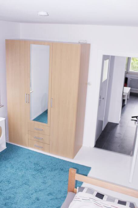 Schlafzimmer mit Schreibtisch und großem Kleiderschrank