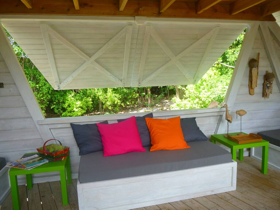 Des banquettes invitent au repos. ..Le carbet s ouvre sur la nature...