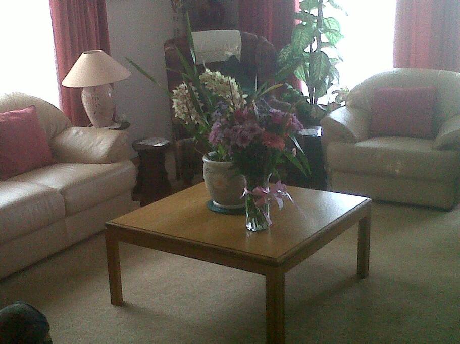 Lounge with leather couches seating 5, 2 lazy boy chairs and two large wingback chairs