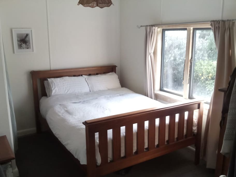 Queen size bed in Bedroom 1 with opening into lounge