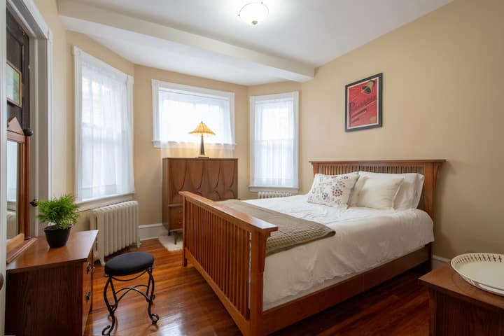 3rd bedroom. Queen bed. Tall chest of drawers. Vanity with mirror. 2 night stands. Seating. Closet with full-length mirror & extra linens. Regal throwback to the arts & crafts architecture period.