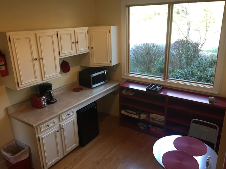 kitchenette with coffee maker, microwave, fridge, silverware, cups and dishes, and sink(in the laundry room)