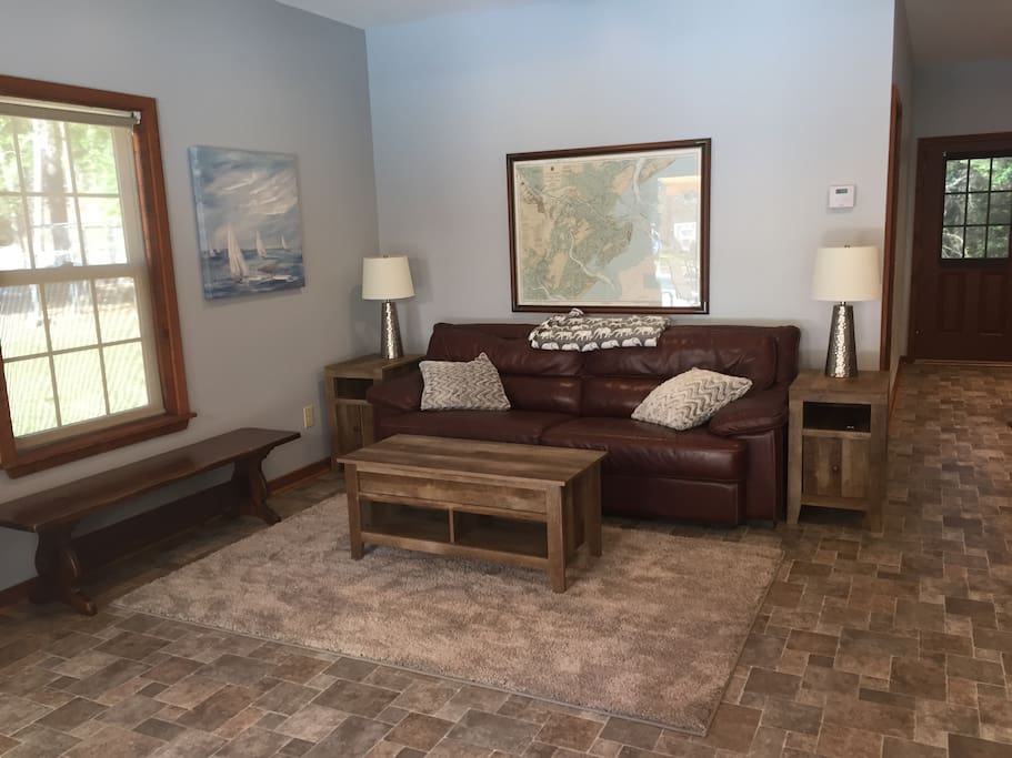 Living room with cable TV, stereo system, & WiFi. Coffee table top lifts up to create a work desk.
