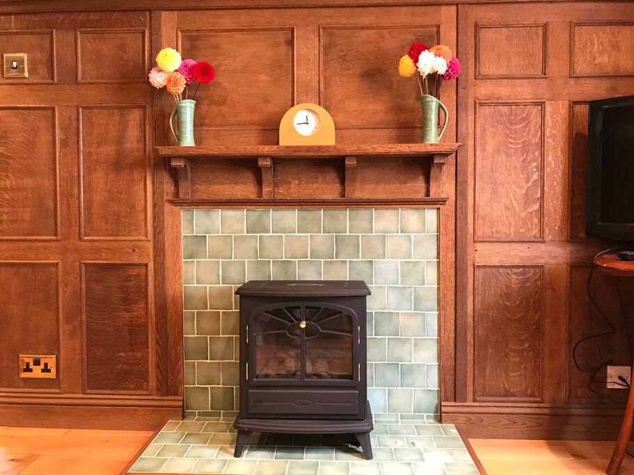 Tudor living room featuring a flue-less gas fire, oak-panelled walls and flat screen TV with BT Youview and Wi-Fi.