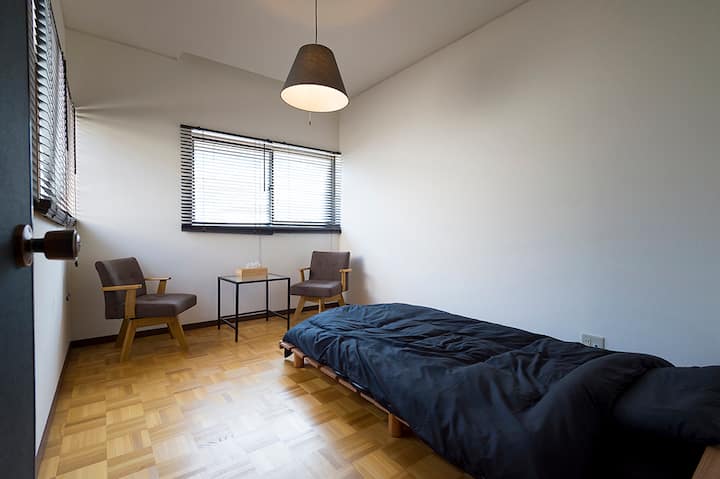 Cozy private bedroom with a single bed.
Perfect for one guest, with a small seating area for relaxing.

シングルベッドのある個室です。
1名での利用に最適で、くつろげるスペースもあります。