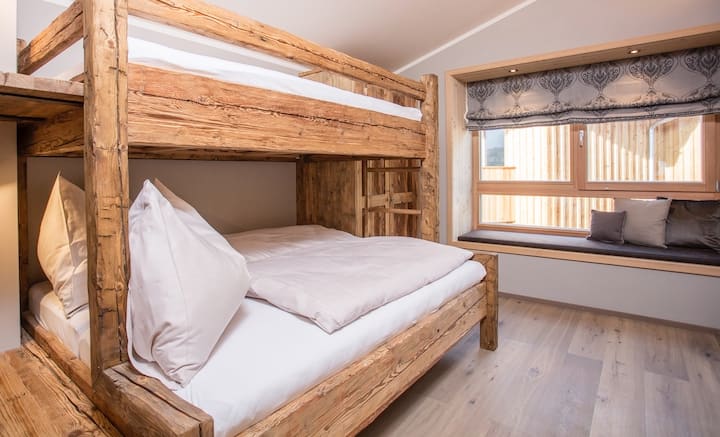 The second bedroom also has a bunk bed made of rustic old wood.