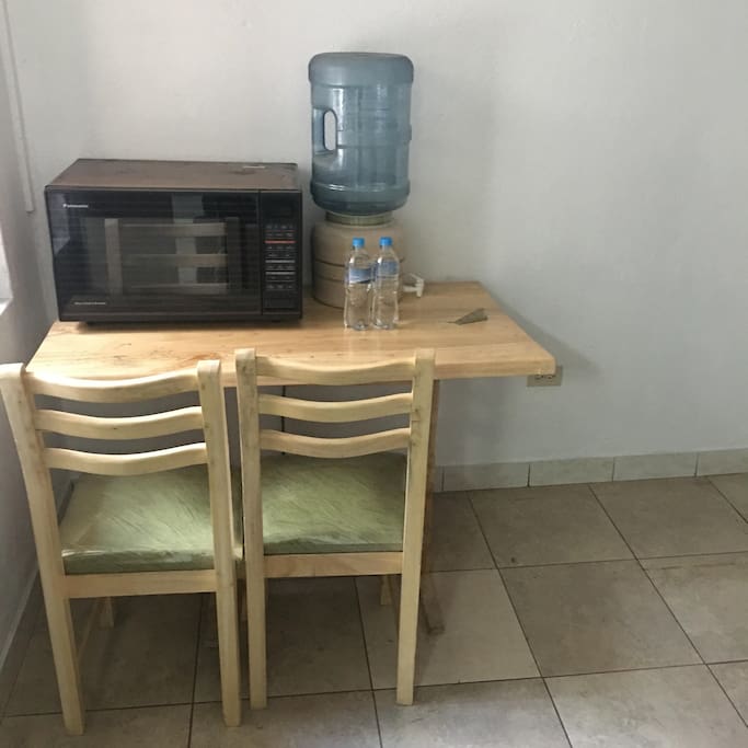 mesa pequeña con sillas y microondas