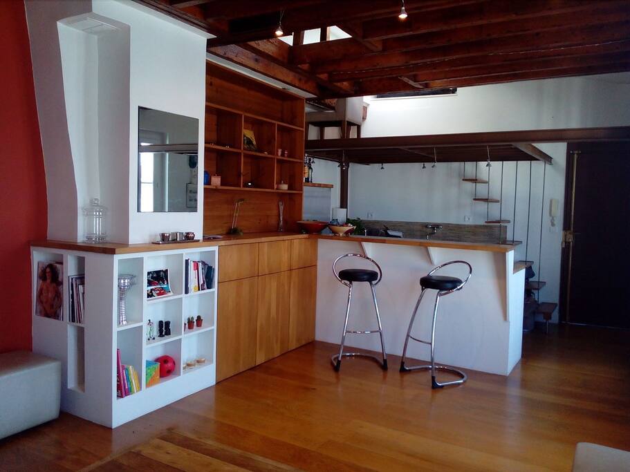 Vue du salon et de la cuisine. Vue de la mezzanine où se trouve l'espace bureau.