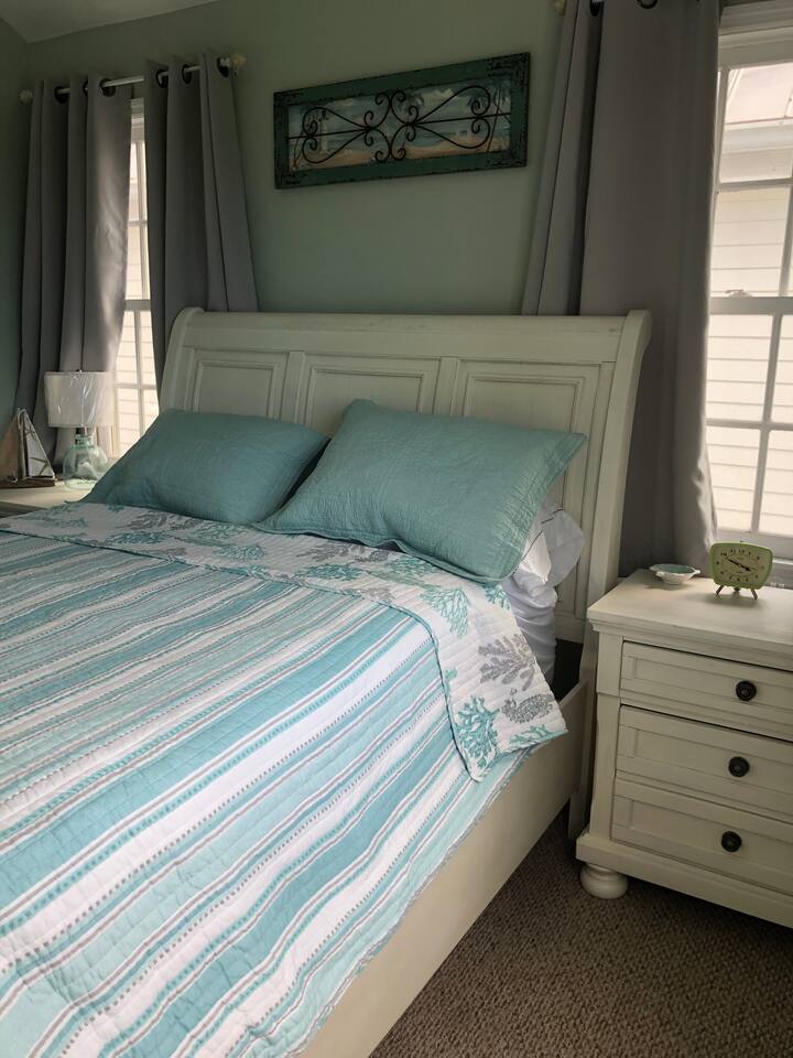 Spálňa s manželskou posteľou a napájanými nočnými stolíkmi na oboch stranách